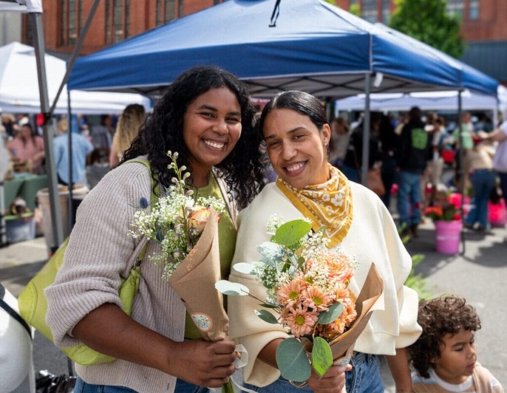 Mother and Daughter at annual event Blooms & Brews at the Lynchburg Community Market holding bouquets of flowers