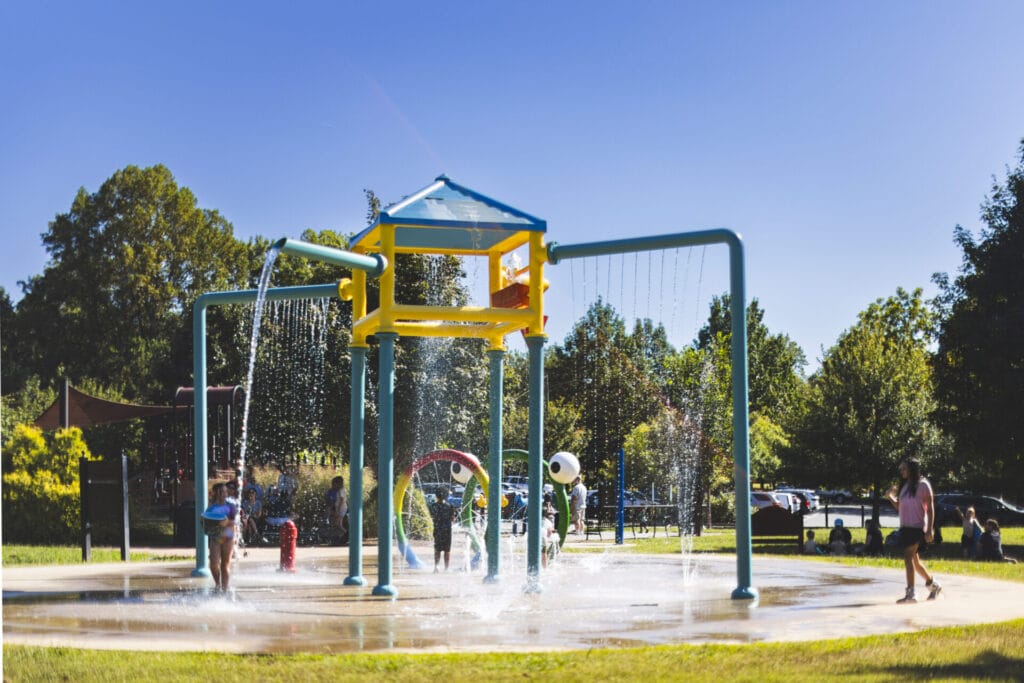 The sprayground spraying out water with kids playing underneath it